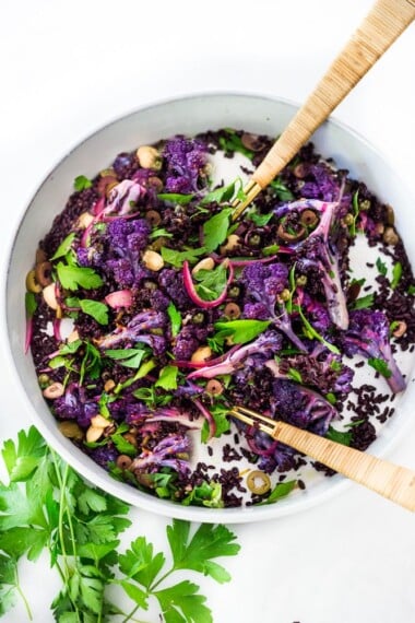 Purple Cauliflower Salad (Sicilian Style!) with olives, grains, capers, parlsely scallions and pickled onions. This vegan healthy salad is easy to make and keeps for several days, perfect for meal prep! | #cauliflowersalad #vegansalad #roastedcauliflowersalad #purplecauliflower