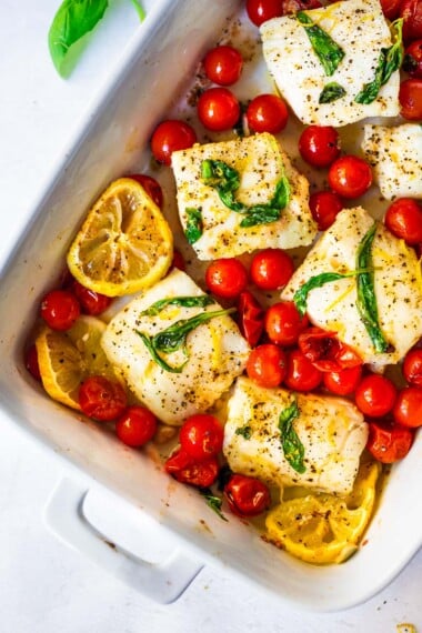 This delicious baked cod recipe features burst tomatoes, basil, garlic, and lemon. It can be made in 30 minutes flat—fast and easy!