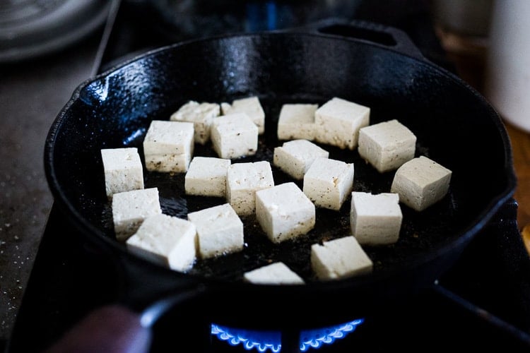 cubed tofu in cast iron skillet.