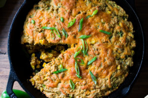 Zucchini Cornbread! A savory zucchini bread infused with Mexican spices, cornmeal, fresh corn and sharp cheddar cheese, baked in a skillet. A cozy side to stew, soup and chili.
