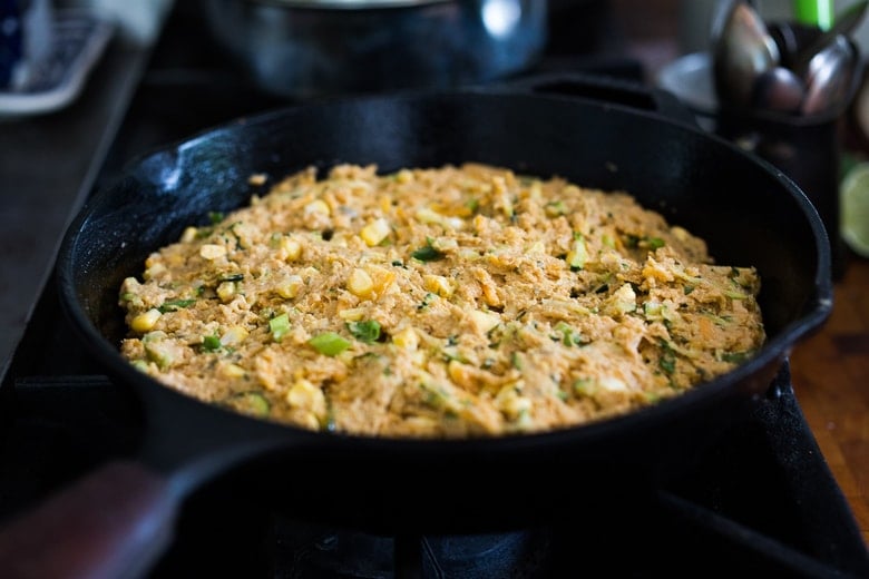 zucchini cornbread unbaked in cast iron skillet.
