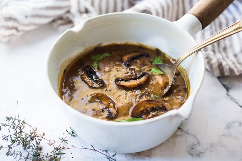 mushroom gravy in saucepan with spoon. 
