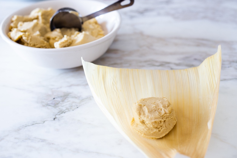 filling the cornhusks with masa dough. 
