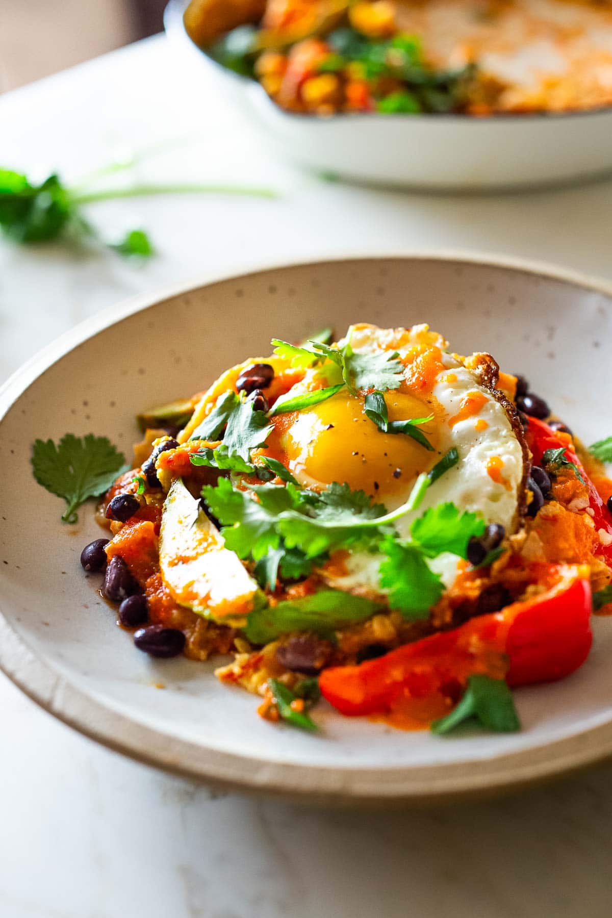 Chilaquiles in a bowl topped with a sunny side egg. 