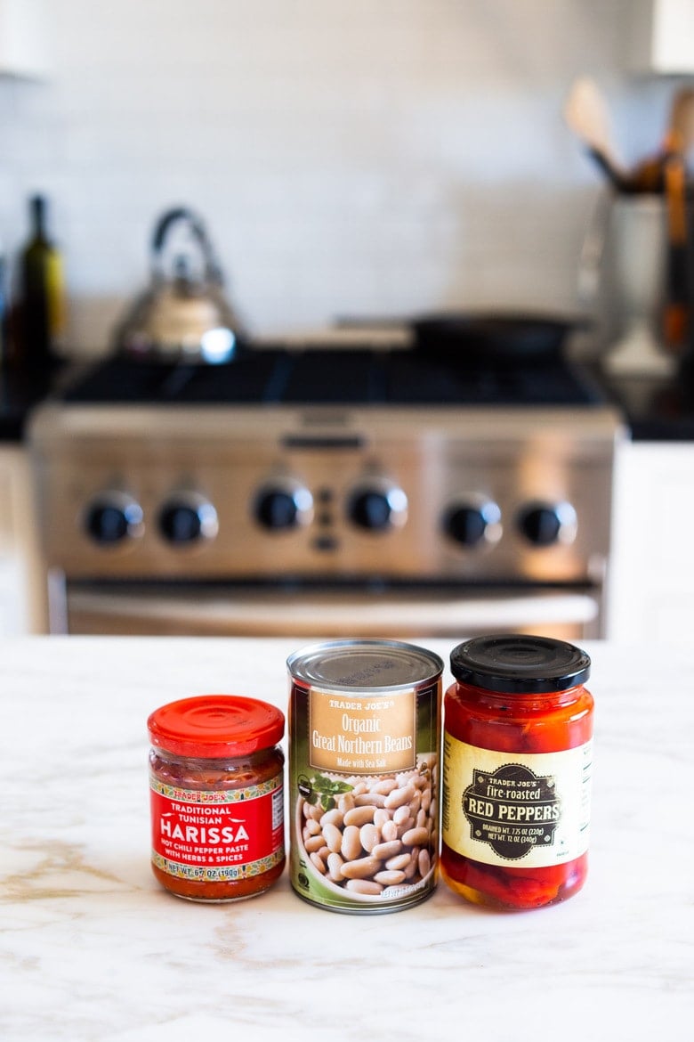 This Smoky Harissa Red Pepper Dip is made with white beans and topped with pistachios, cumin seeds and optional feta. A simple party appetizer that comes together in 10 minutes flat. #harissadip #vegandip #harissahummus #whitebeandip #redpepperdip #redpepperhummus 