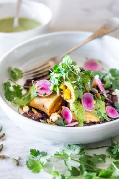 These vegetarian tamales are delicioius! Made with a creamy butternut squash filling,  topped with a flavorful poblano sauce and served over a bed of seasoned black beans, with pickled red onions. They are gluten-free and easily vegan-adaptable!