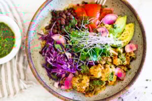 Smokey Cauliflower Chimichurri Bowls! These filling vegan bowls are full of flavor and loaded up with healthy veggies. Served over seasoned black beans (and optional rice) with Mexican Slaw, radishes, avocado, cilantro and pickled onions. #roastedcauliflower #bowls #veganbowls #veganrecipes #buddhabowls #chimichurri #eatclean #cleaneating #plantbased #healthybowls