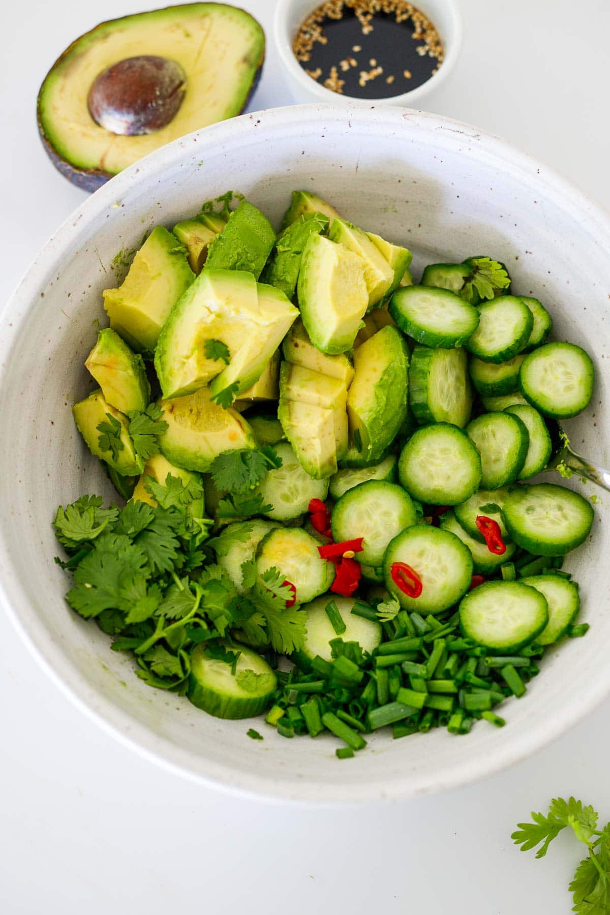 avocado salad ingredients in a white bowl. 