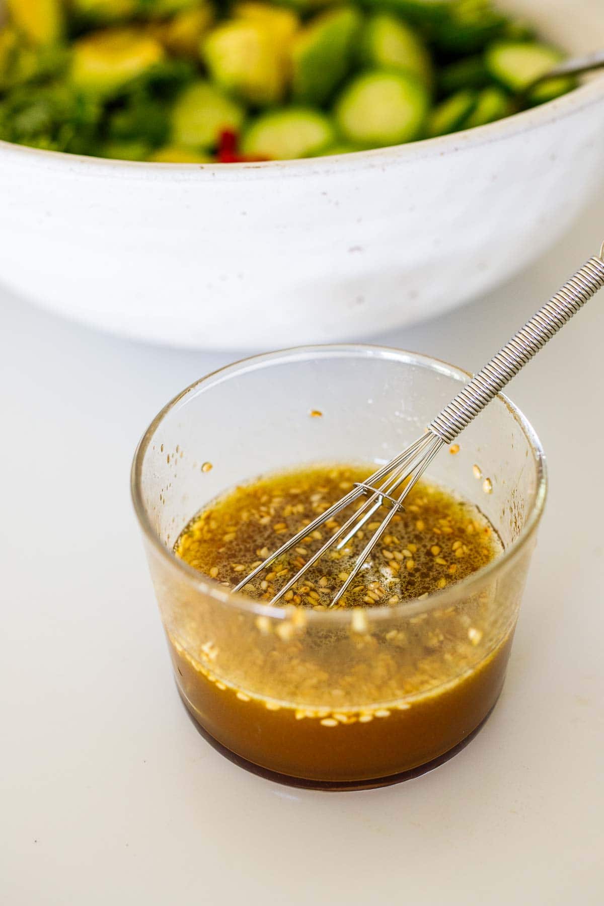 japanese style dressing in a bowl with a mini whisk. 