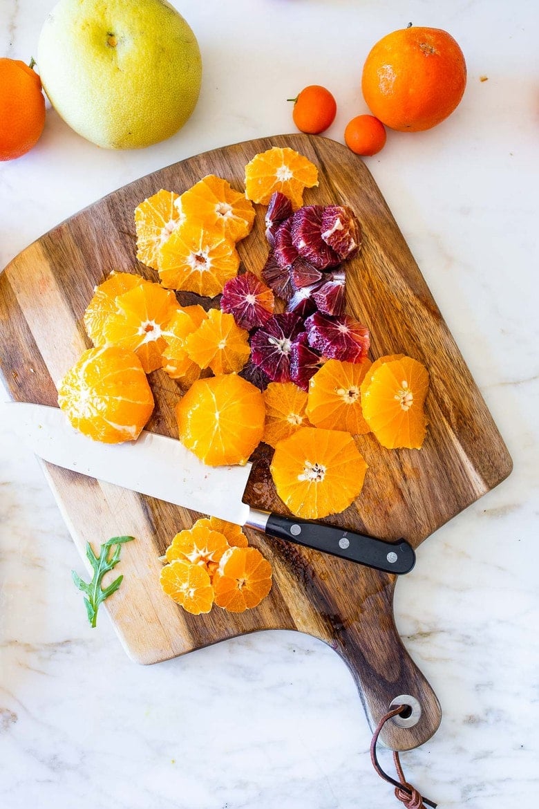 This Moroccan-inspired Citrus Salad with dates, arugula, mint, pistachios, and toasted coconut is dressed in the most flavorful Citrus Shallot Vinaigrette. It's deliciously juicy and vegan! #citrussalad #orangesalad
