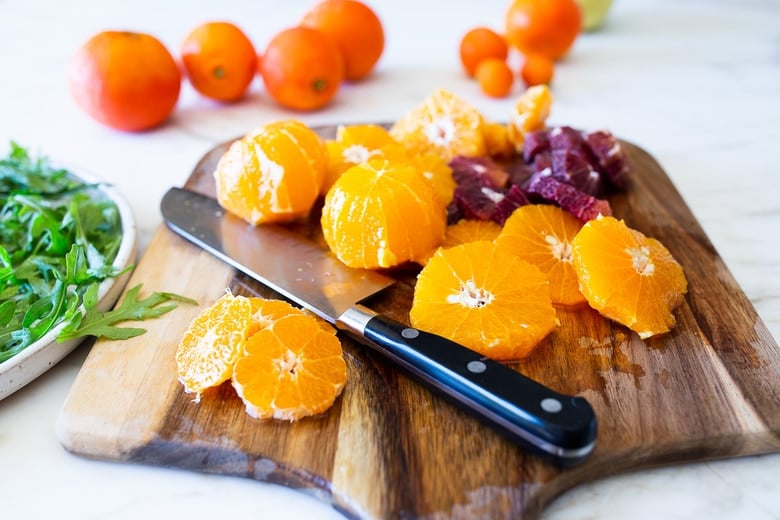 This Moroccan-inspired Orange Salad with dates, arugula, mint, pistachios, and toasted coconut is dressed in the most flavorful Citrus Shallot Vinaigrette. It's deliciously juicy and vegan! #citrussalad #orangesalad