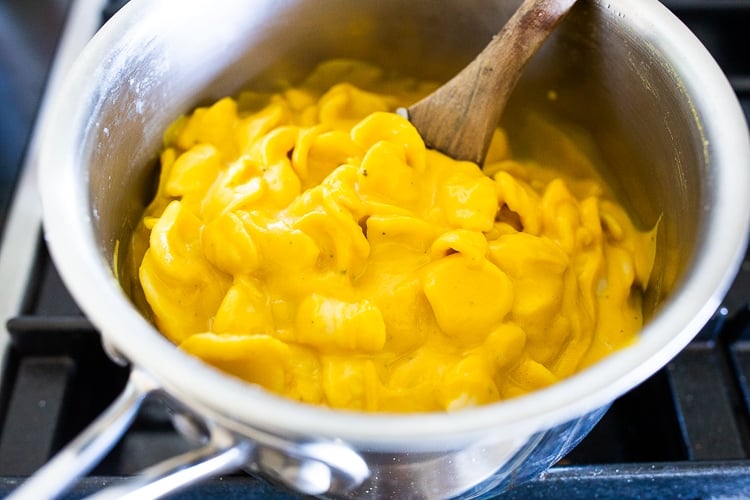 orecchiette combined with creamy carrot pasta sauce in pot.