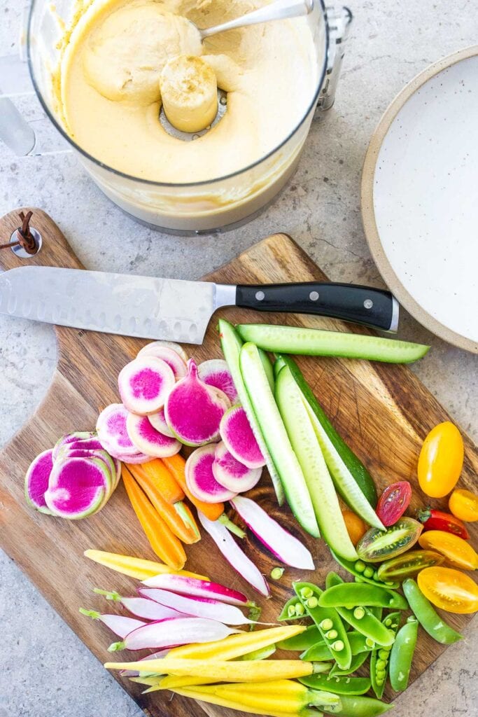 Adding veggies to hummus platter
