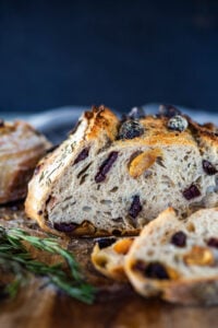 How to make Crusty Sourdough Bread, infused with rosemary, roasted garlic and olives that requires no kneading and rises overnight. Made with sourdough starter instead of yeast! #sourdoughbread