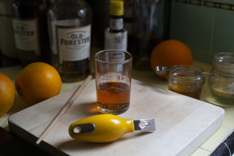 measuring the bourbon in a shot glass. 