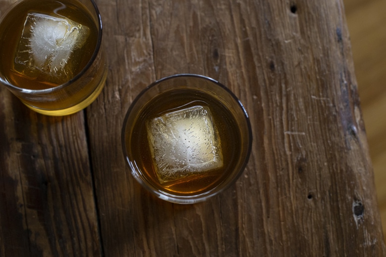 a classic Old Fashioned Cocktail with big ice cubes in rocks glasses. 