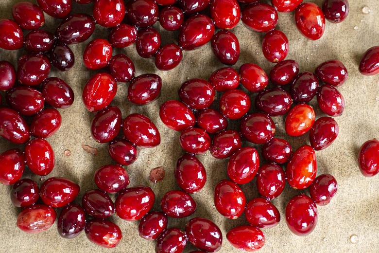 A festive holiday cocktail made with assertive rye whiskey, enlivened with tart cranberry & lemon, the whole softened by 2 festive liqueurs; garnished with a bit of holiday fruit, or (depending on how you've been this year) - a lump of "coal".