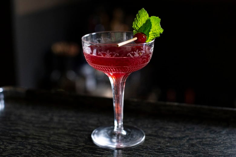 A festive holiday cocktail made with assertive rye whiskey, enlivened with tart cranberry & lemon, the whole softened by 2 festive liqueurs; garnished with a bit of holiday fruit, or (depending on how you've been this year) - a lump of "coal".