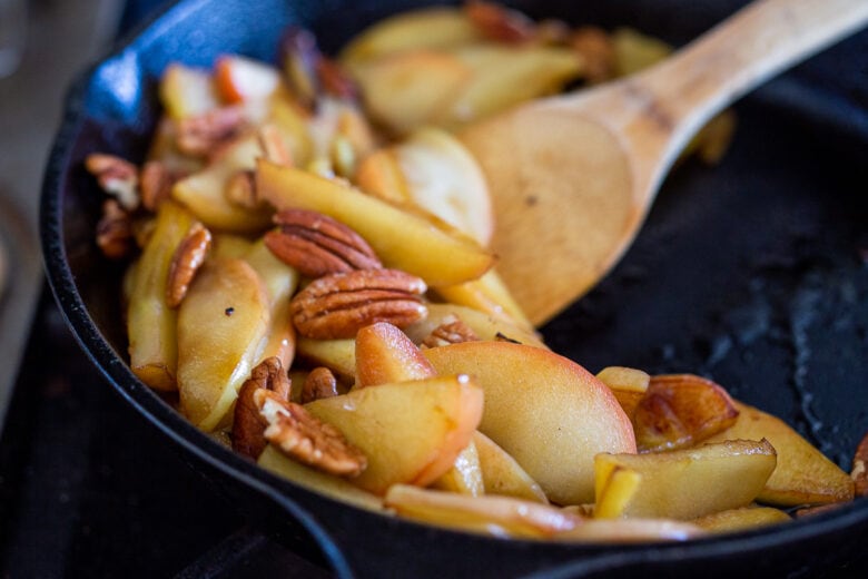 sautéing the apples and pecans in cast iron skillet with wooden spoon. 