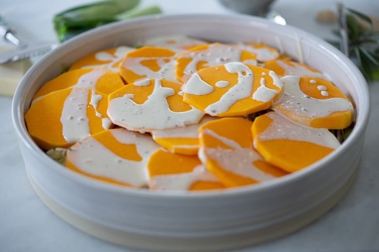 the seasoned cream drizzled over top of the top layer of the butternut squash gratin. 