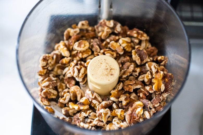 toasted walnuts in bowl of food processor. 