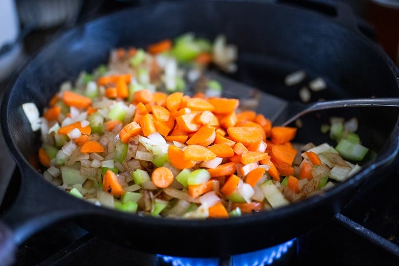 sautéing carrots, celery, and onions in cast iron skillet with metal spatula. 
