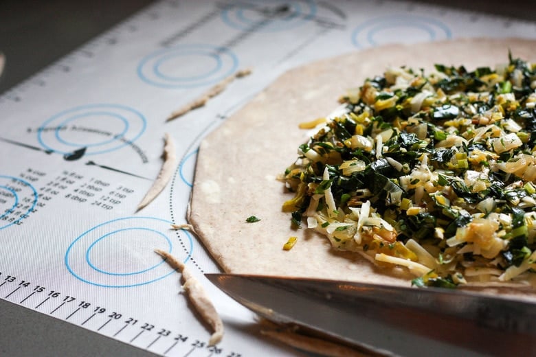 savory leek and kale filling added to galette dough, leaving 2 inches empty and using knife to slice off rough edges.