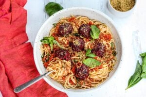 Vegan Spaghetti and Beetballs! A beautiful twist on the comforting familiar classic. Beets, black beans, walnuts and basil make these plant-based meatballs scrumptious and so satisfying. Top with an easy rustic tomato sauce for a meal the whole family will love! #vegan #veganmeatballs #beetballs #spaghetti #veganspaghetti