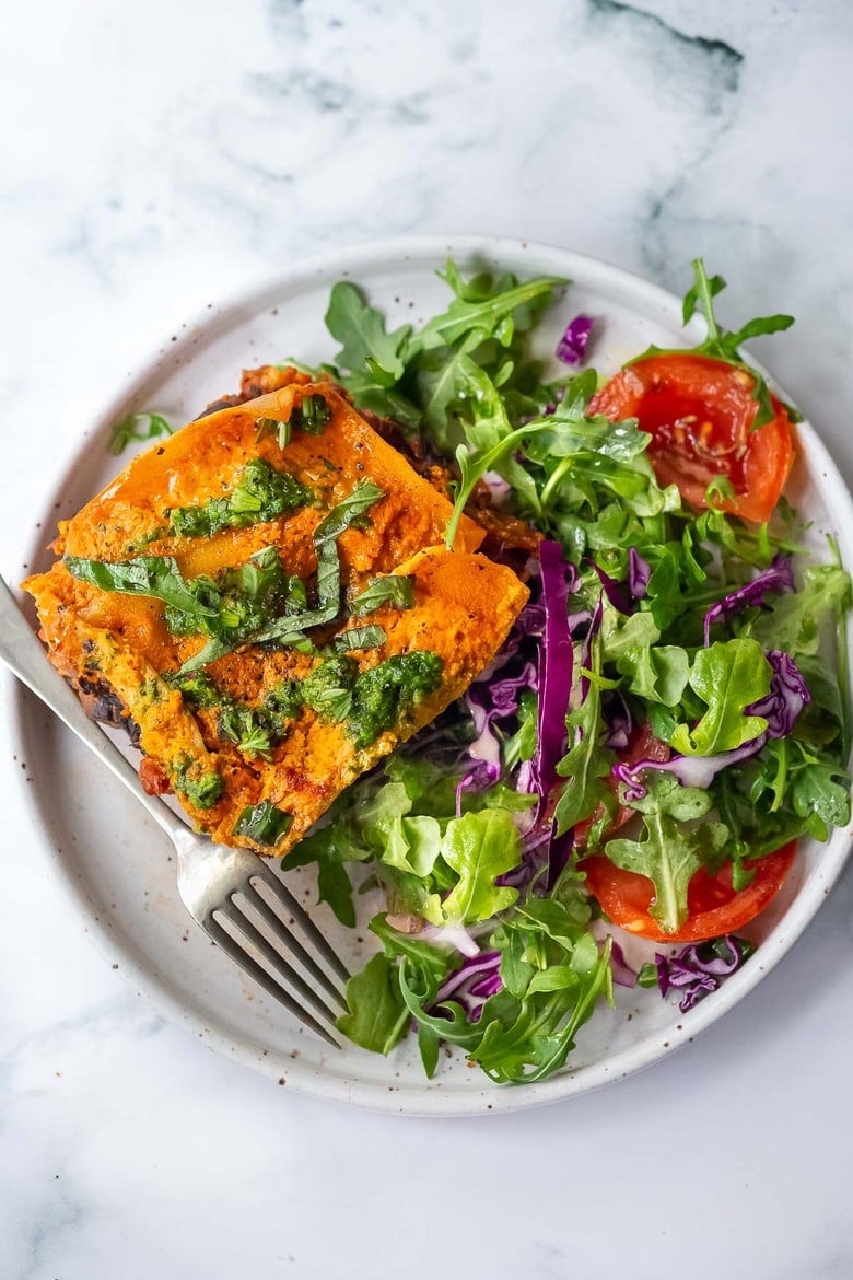 This Vegan Lasagna is made with a robust mushroom-spinach bolognese sauce, fresh basil, vegan ricotta and no-boil lasagna noodles, topped off with a creamy marinara sauce, drizzled with Arugula Basil Pesto. Vegan comfort food at its best! #veganlasagna #vegandinnerrecipes #vegan #lasagna #mushroombolognese 