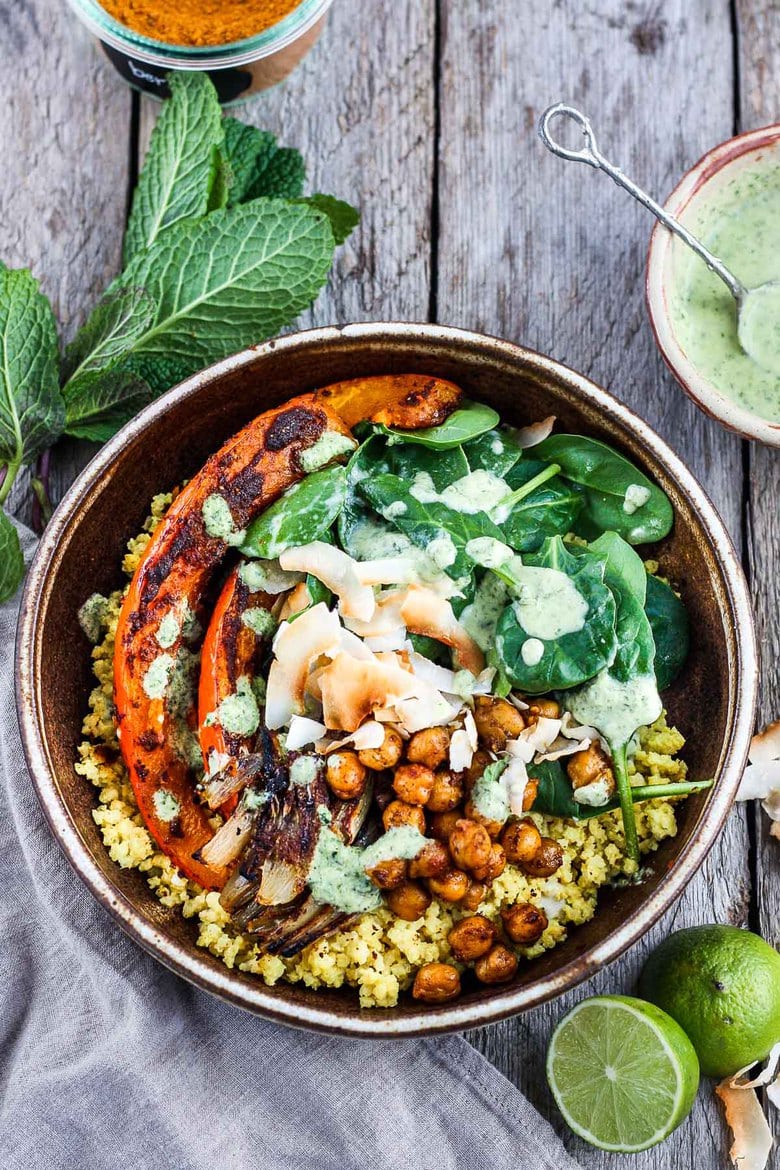 Coconut Millet Bowl with Berbere-Spiced Kabocha Squash, chickpeas, shallots, and spinach drizzled with coconut lime mint sauce. A vegan, plant-based meal, full of vibrant flavor and spice.