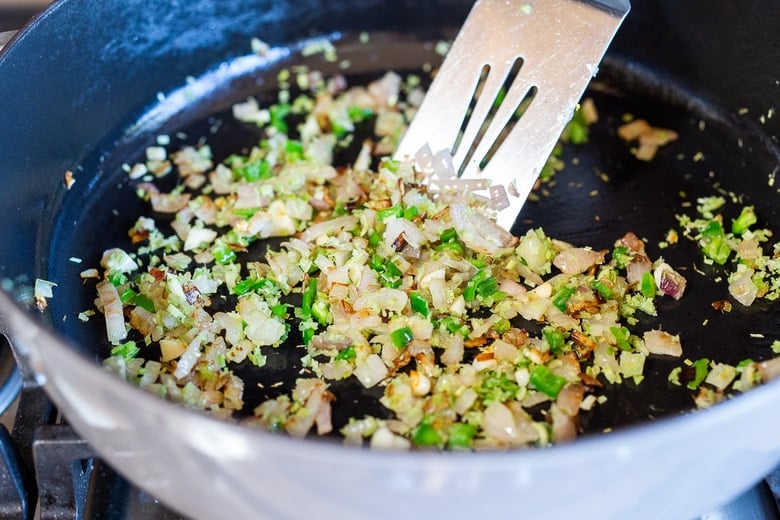 sautéing shallots, chilies and garlic in pan with metal spatula.