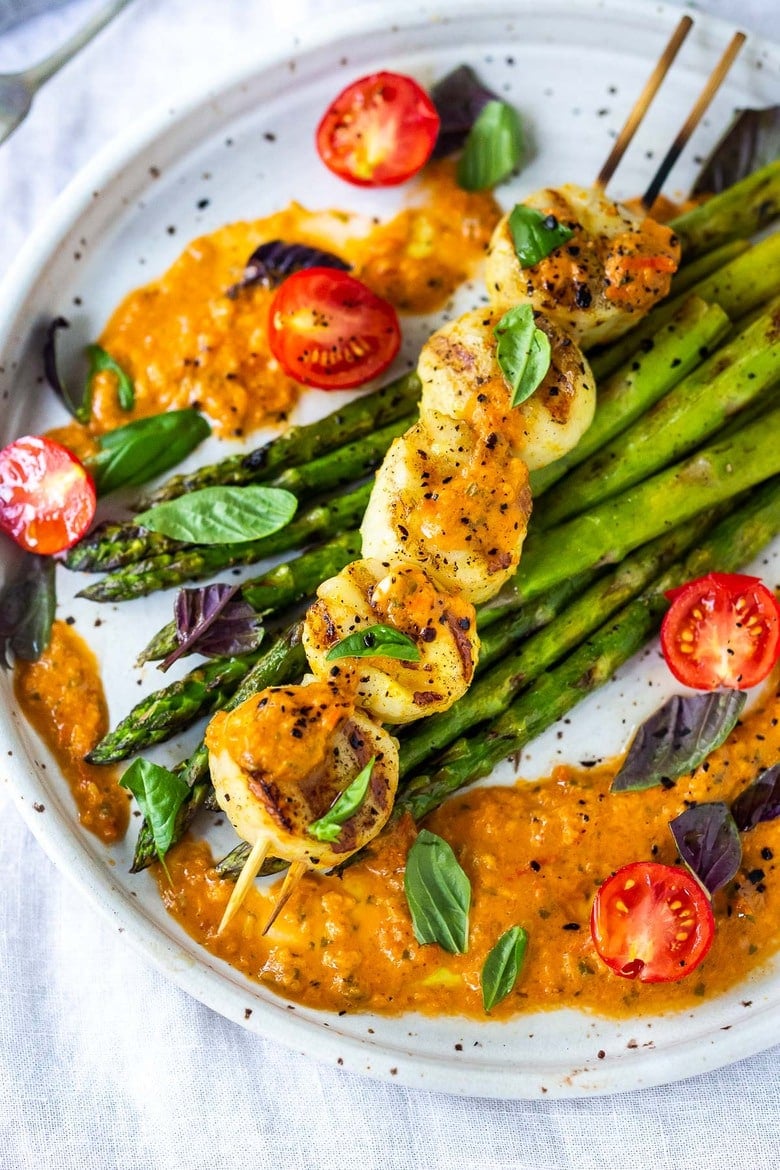 grilled scallops on skewer laid atop grilled asparagus, drizzled with charred tomato vinaigrette and fresh basil.