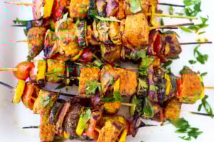 Grilled Veggie Kabobs with your choice of protein (tempeh, tofu, chicken, or shrimp) loaded up with healthy summer veggies and a flavorful harissa yogurt sauce. Vegan adaptable! 