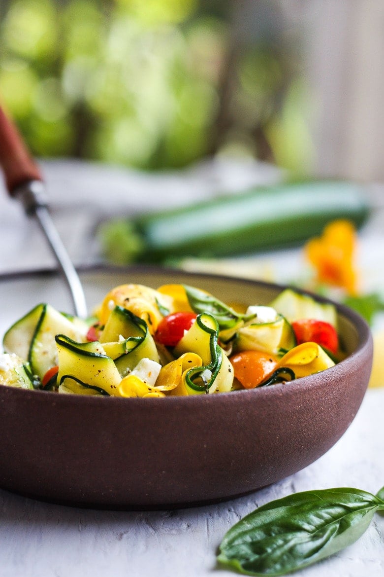 pasta bowl with zucchini ribbons with quartered cherry tomatoes, feta, and cracked pepper.