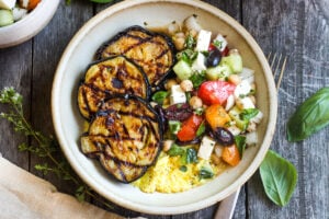 Perfectly tender smoky Grilled Eggplant with fresh Greek relish and creamy polenta. An easy and healthy meatless dinner. Vegan adaptable and gluten-free.