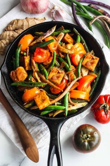 Green Bean and Tofu Stir Fry is full of crunch and flavor.   Spiced up with red curry paste, shallots, ginger and lemongrass for a quick, savory Thai-inspired meal.   Vegan and GF.