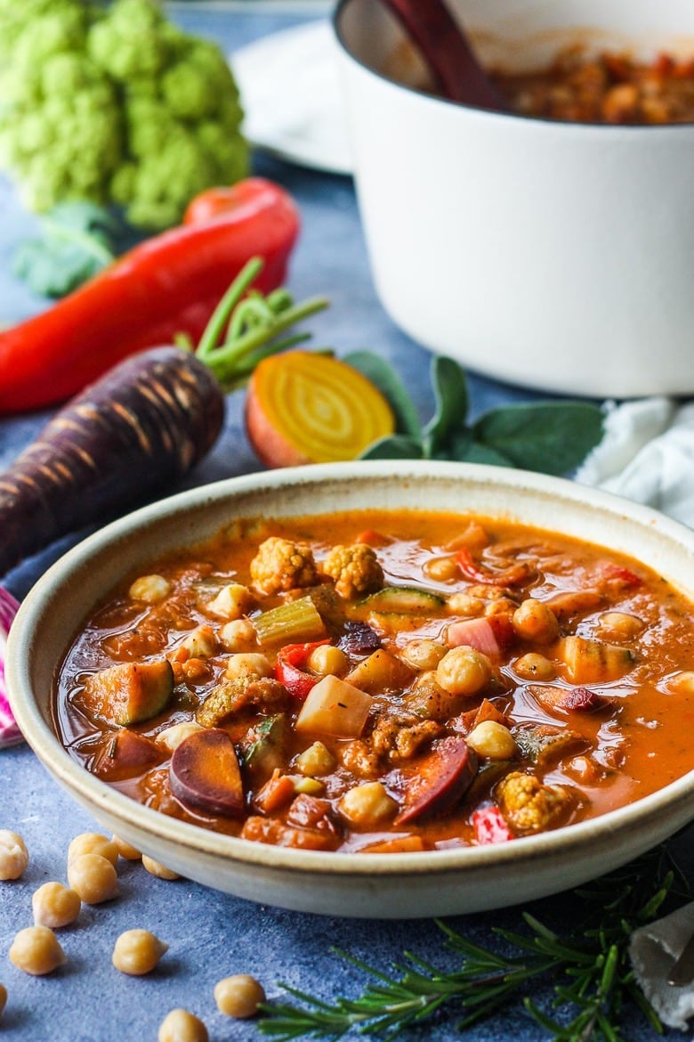 This Harvest Vegetable Soup recipe is so cozy and nourishing! Packed with seasonal veggies and chickpeas in a luscious roasted tomato base with fresh herbs. Vegan & delicious!