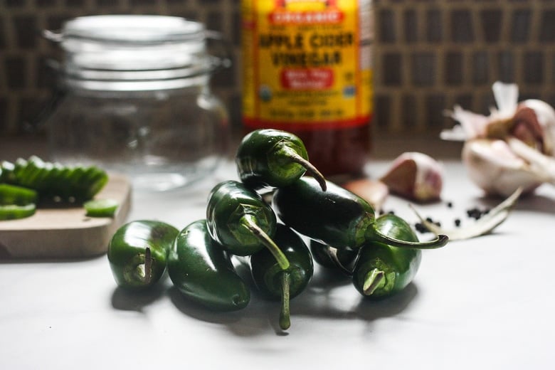 ingredients in pickled jalapeños on a counter.