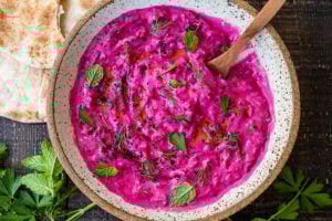 Vibrant Beet Tzatziki made with grated beets, cucumber, Greek yogurt and fresh herbs- a festive appetizer or complementary side dish to Mediterranean-inspired meals. Vegan-adaptable!