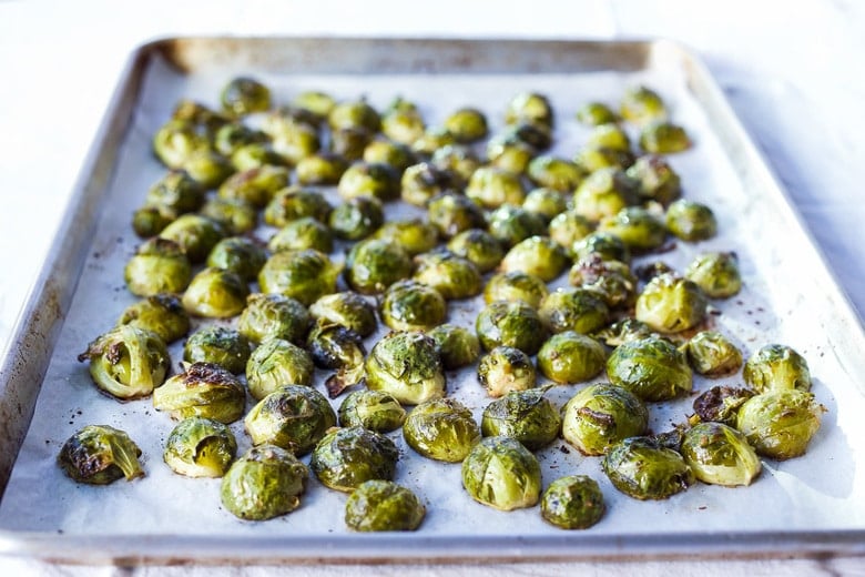 baking sheet with roasted brussels sprouts cut side down on parchment.