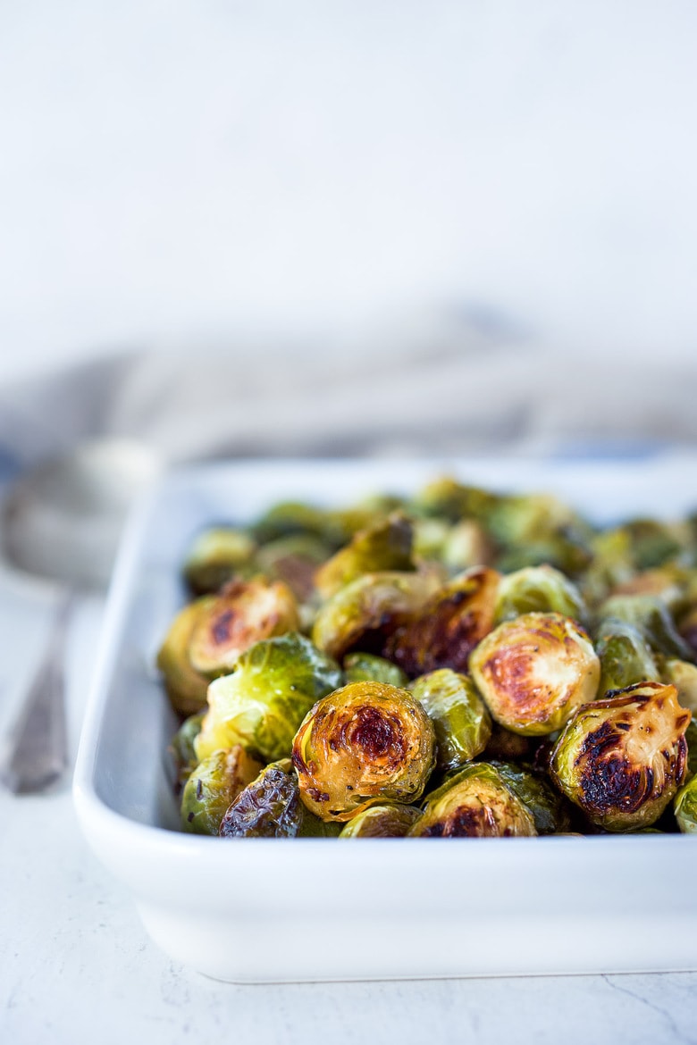 Roasted Brussels sprouts rectangular baking dish with roasted brussels sprouts.