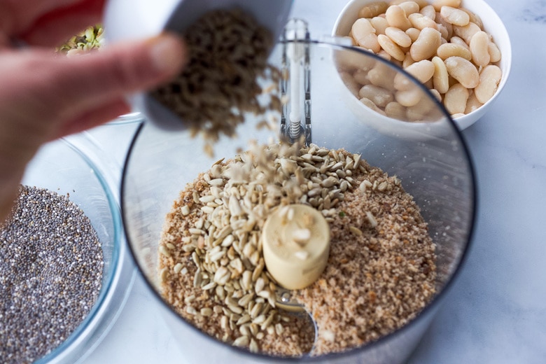 food processor with bread crumbs adding in sunflower seeds