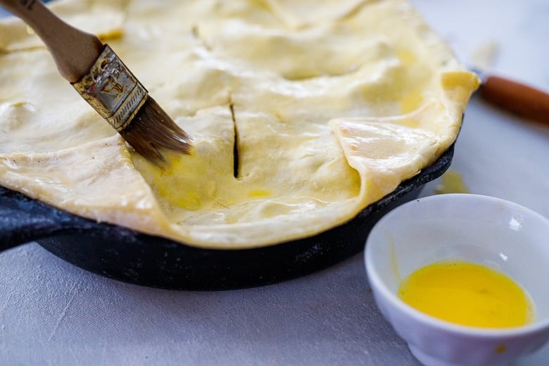 fold up the corners of the puff pastry, slit the pot pie for venting and brush with olive oil.