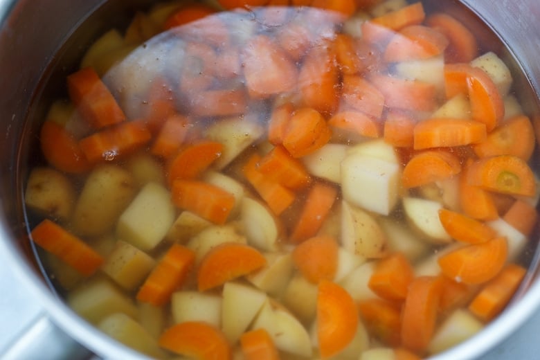 par boiling potatoes and carrots.