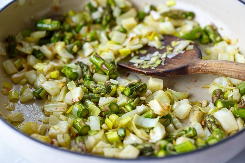 Making the filling, sauteeing veggies in a pan. 