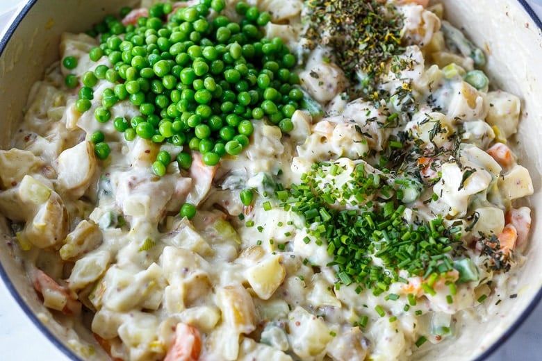 adding fresh herbs and peas to the pot pie filling. 
