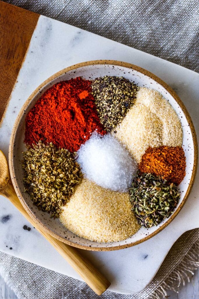 small dish with each spice for cajun seasoning in a pile, unmixed.