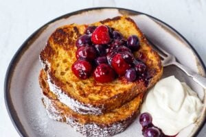 An easy recipe for tender French Toast enhanced with spices, orange zest, and lightly sweetened with maple syrup. Top with Fresh Berry Compote for a perfect weekend breakfast treat.
