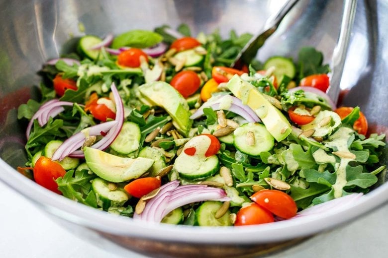 tossing the salad with the dressing