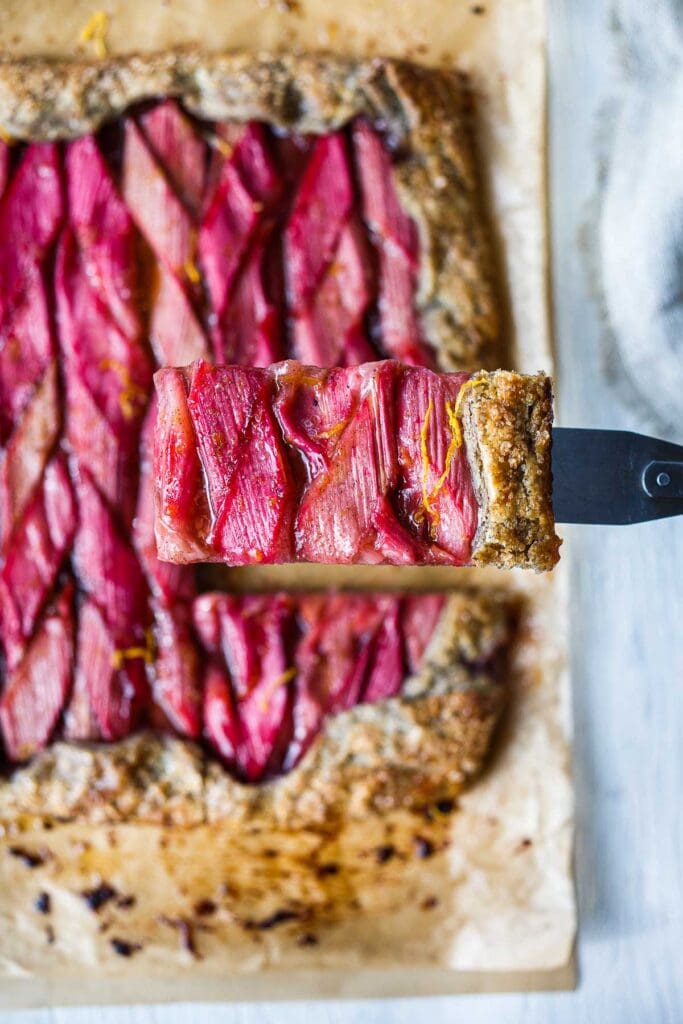 A rustic Rhubarb Tart with lemon, cardamom and vanilla tucked into a flakey free-form buckwheat crust. Simple, elegant, and delicious!